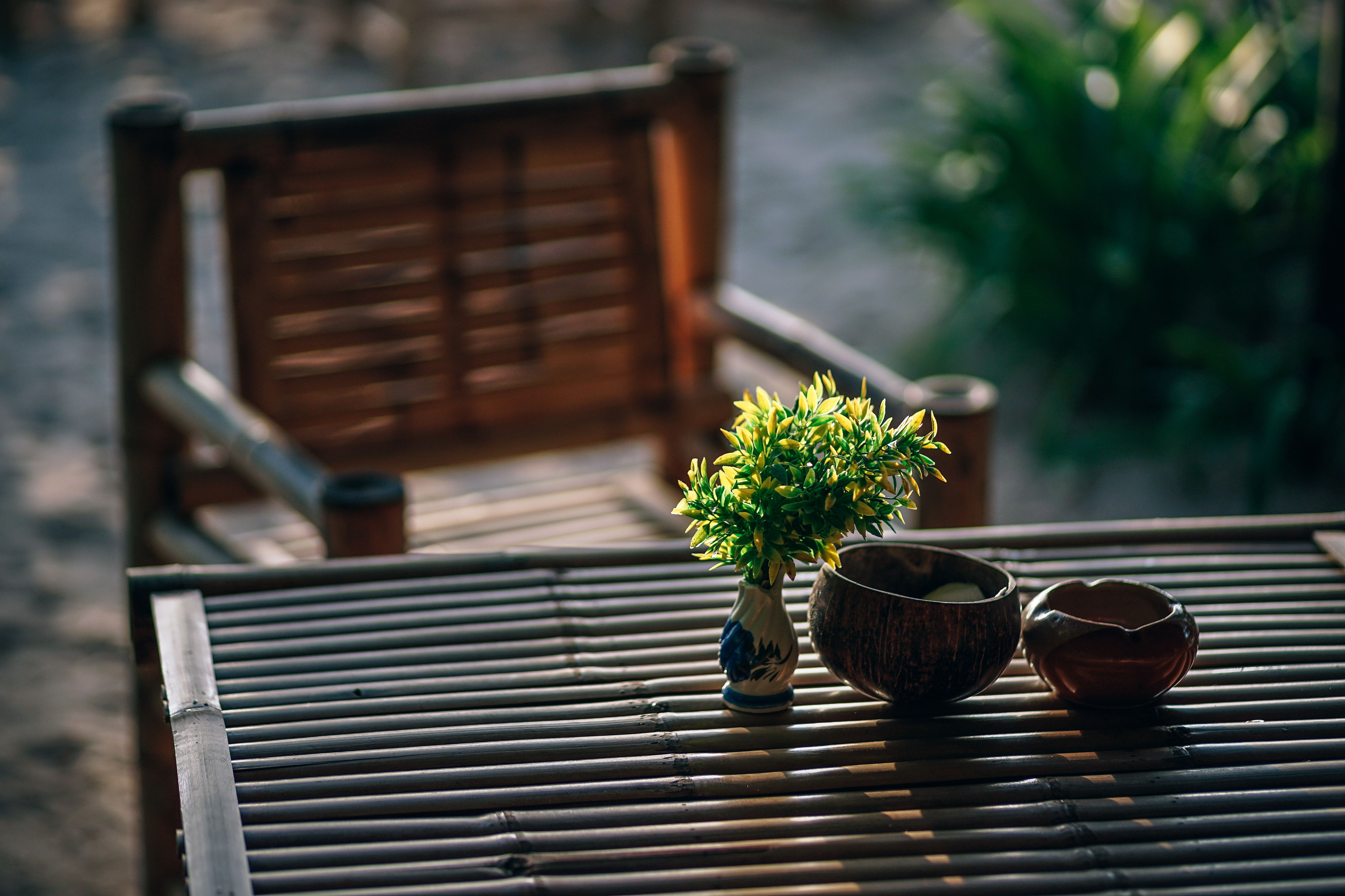 An Upaskar outdoor bamboo chair set on a Canadian patio — two deep-seated lounge chairs with all-weather cushions and a low bamboo coffee table surrounded by planters